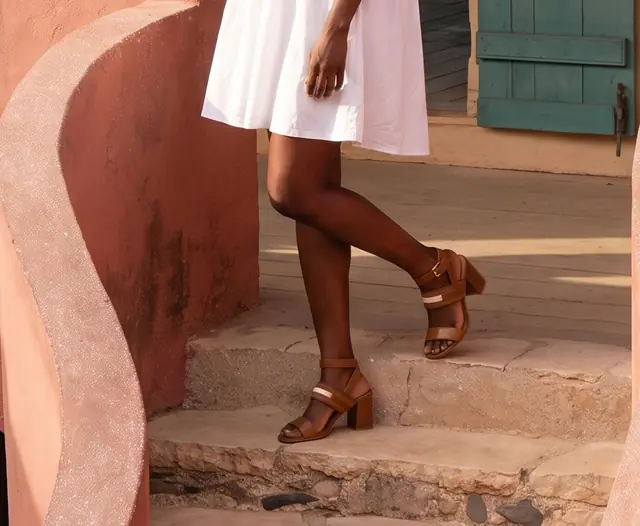 Une cliente en sandales a talon, sur les marches d'une maison de Goree.